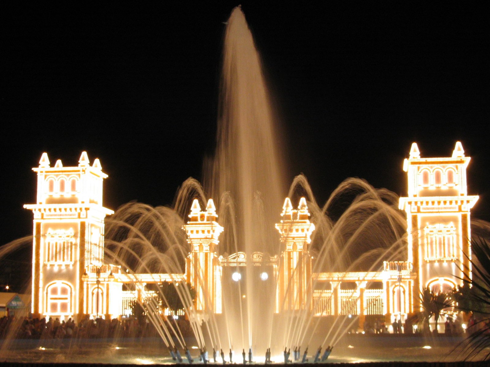 the fountain is illuminated up at night for people to see