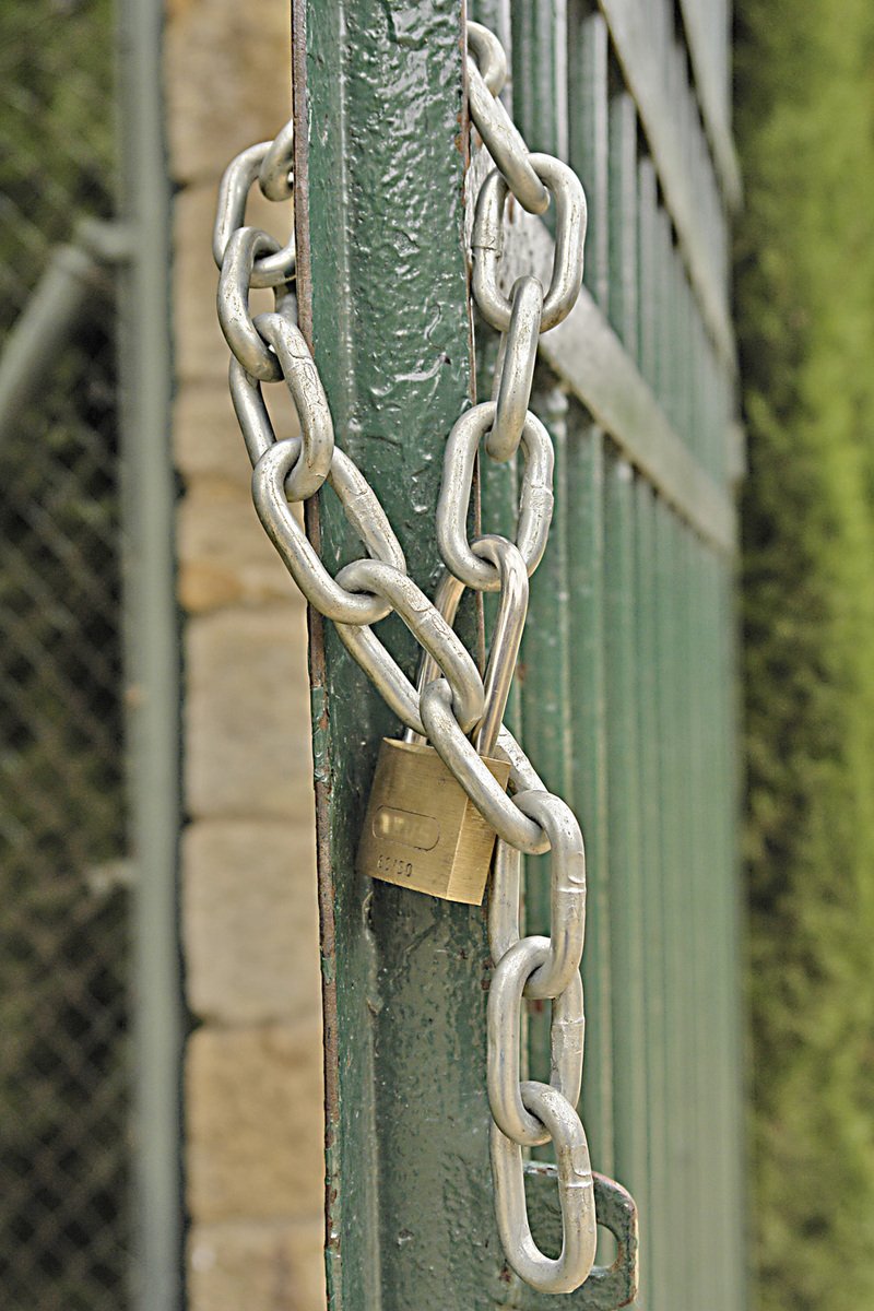 close up view of the lock and chain on a green gate