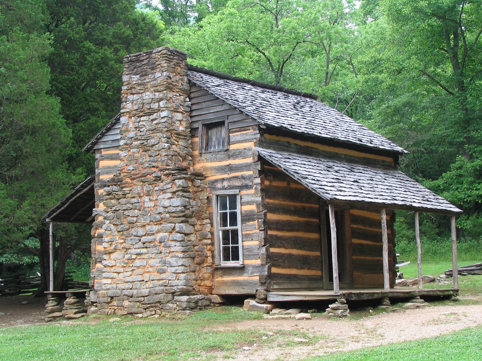 there is an old log cabin that is built into the grass