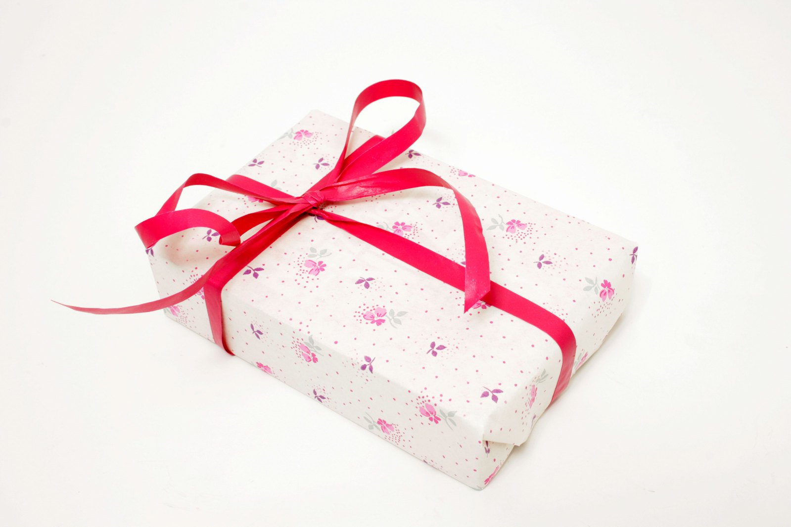 a wrapped present box with pink ribbons