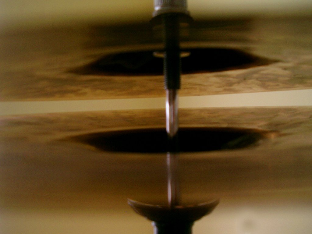 water gushing onto floor below a shiny pole