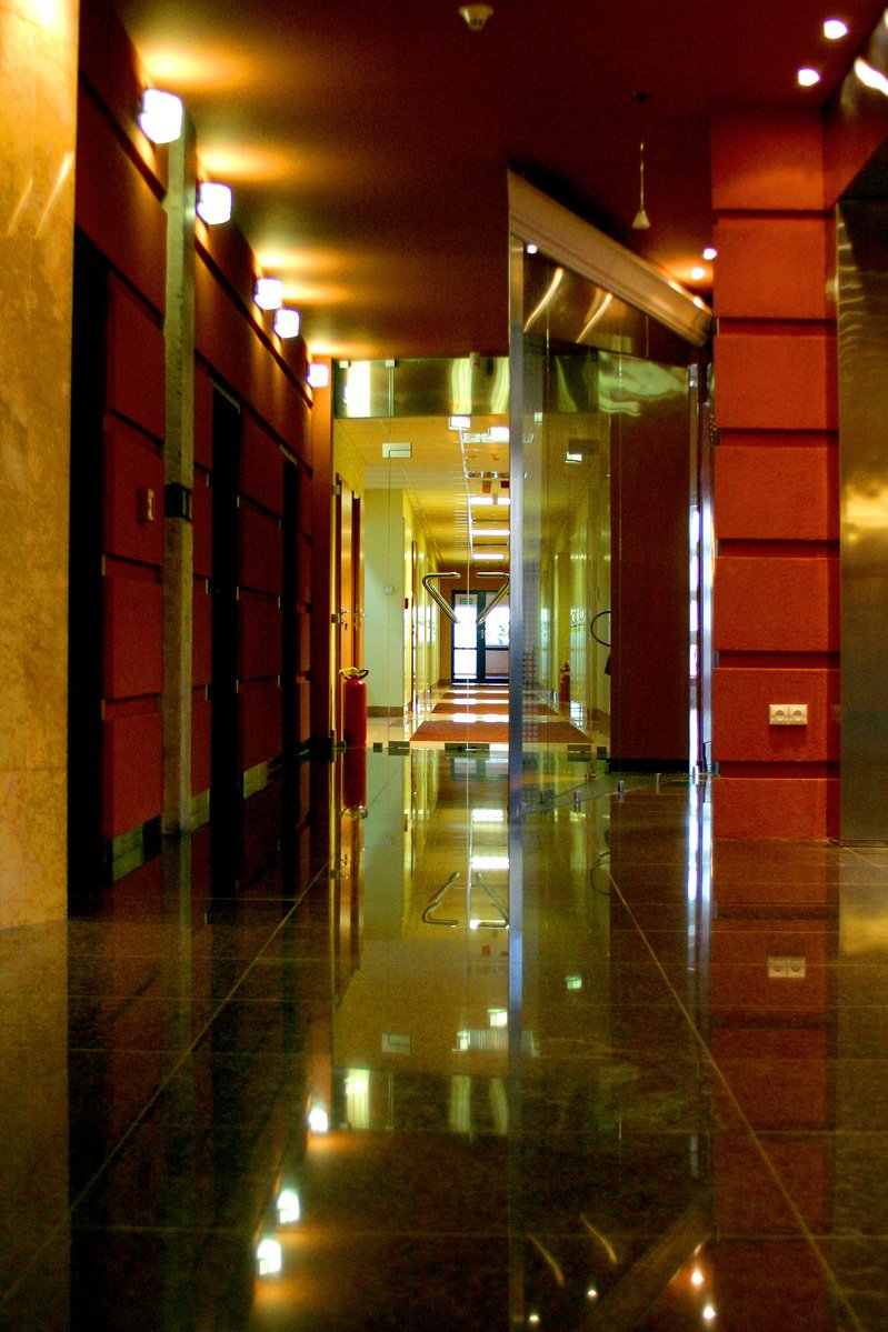 an empty hallway with lights reflecting off the wall