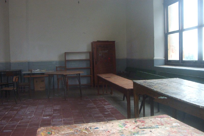 a room with lots of desks, windows and a door
