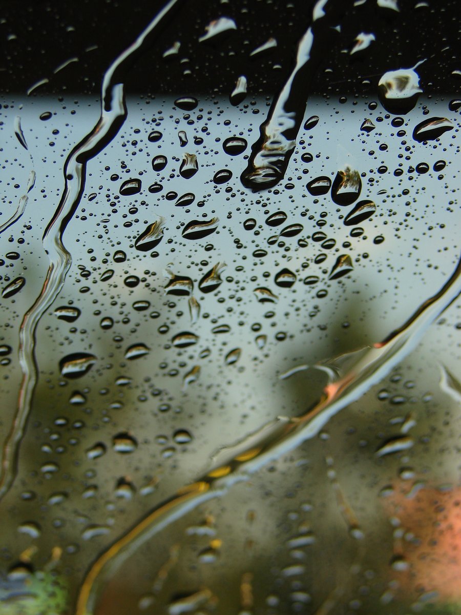 rain is seen on the window and glass