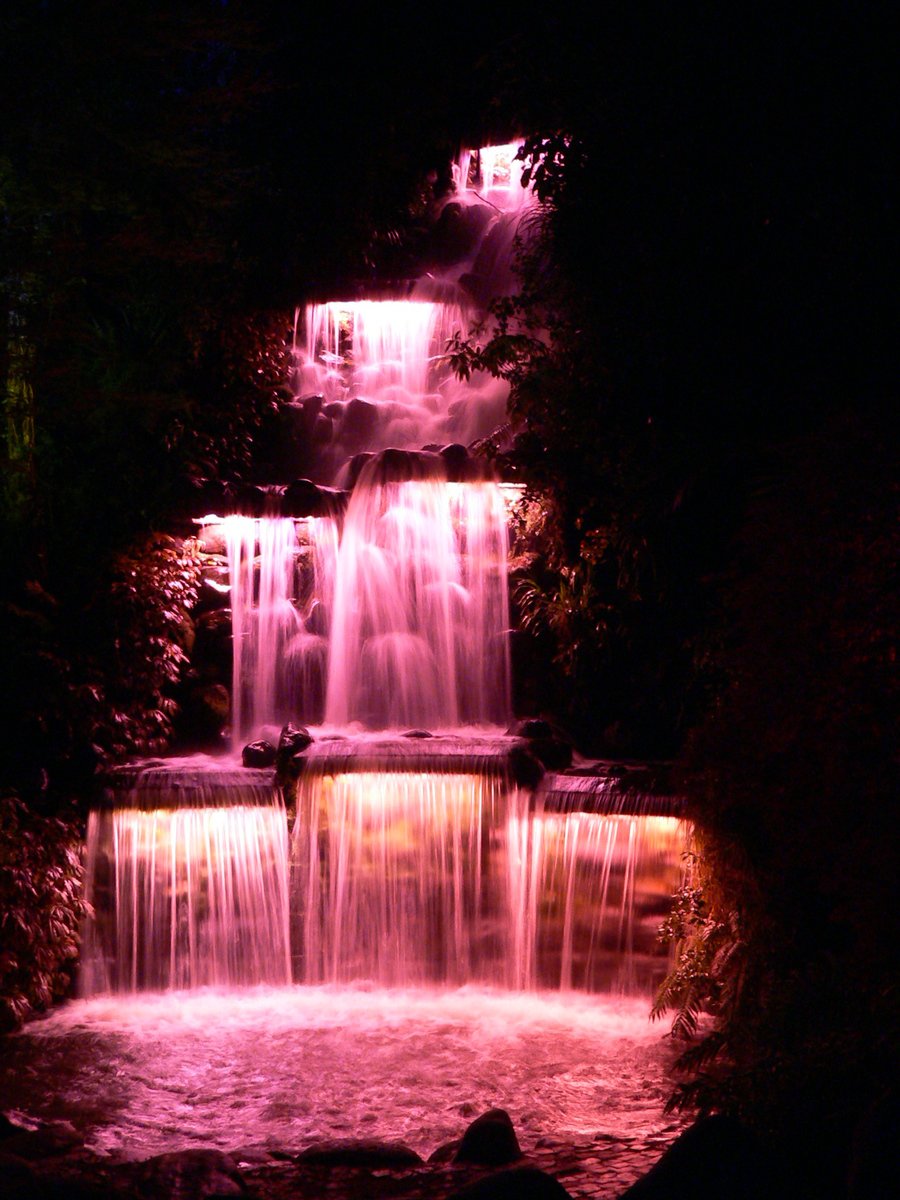 a bunch of waterfalls are lit up at night