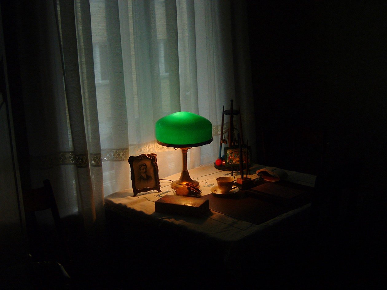a lamp sits next to some boxes and a chair