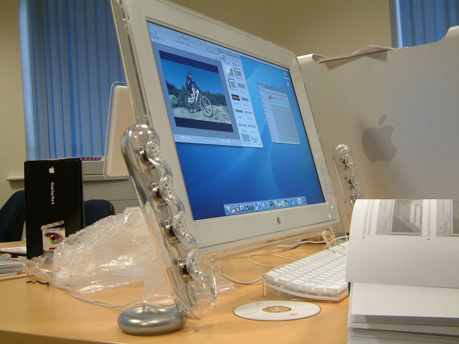 an apple computer in a white box with the keyboard, mouse and other items