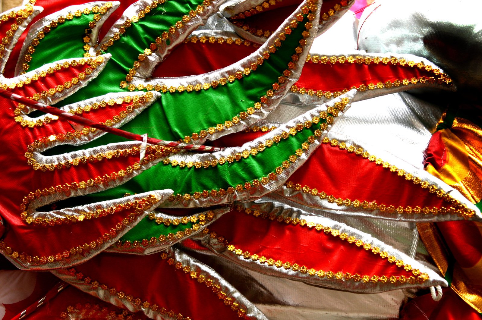 a group of red, green and gold costumes with long ribbons
