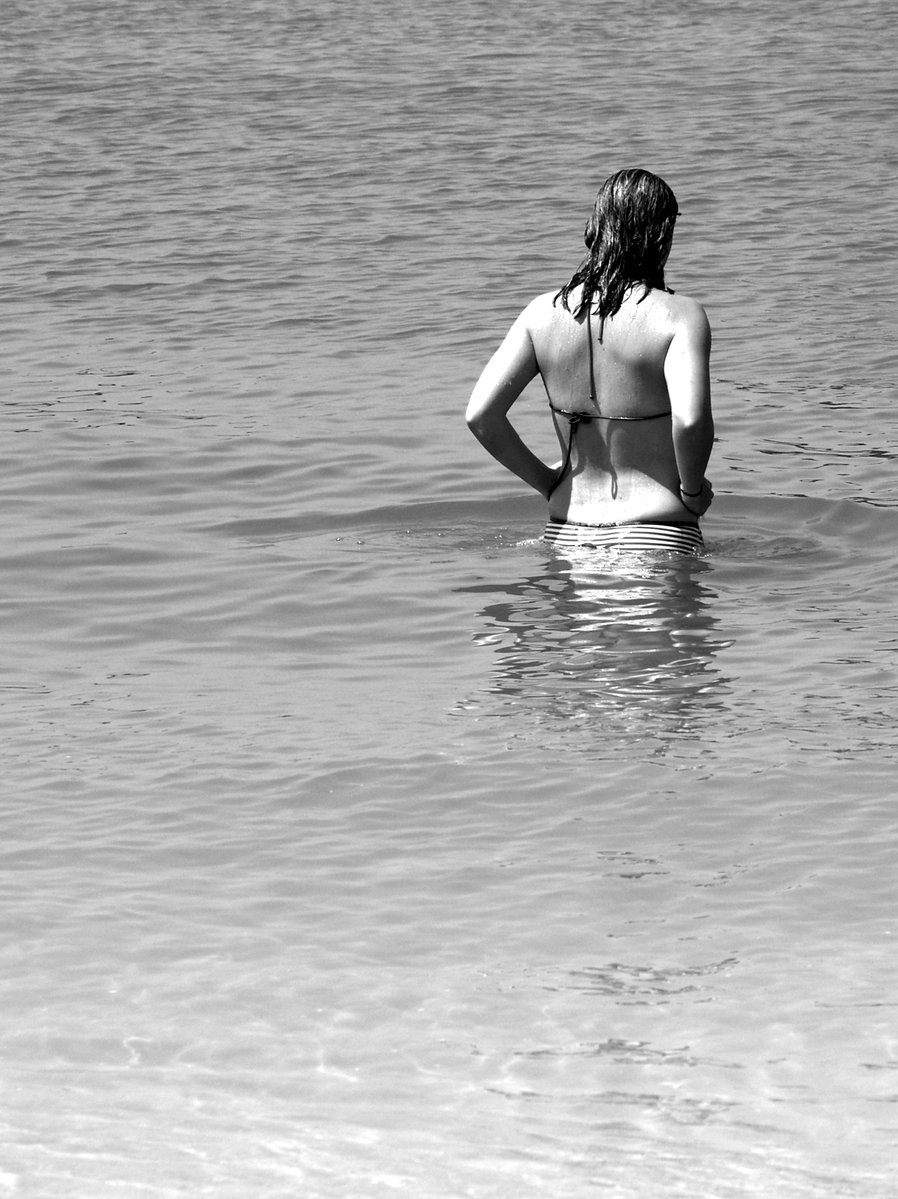 a woman with her hand behind her back in the water