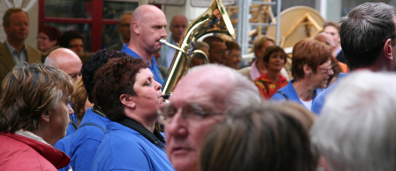 a woman in a blue jacket is looking up at the crowd