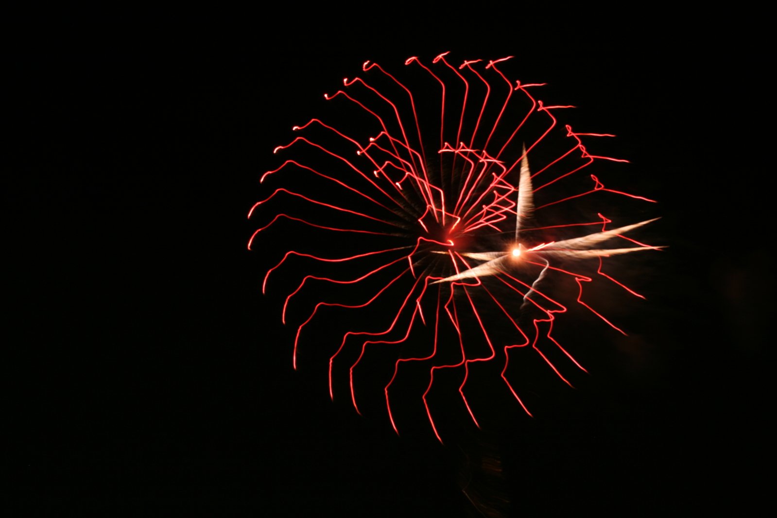 a red fireworks in the dark on a black background