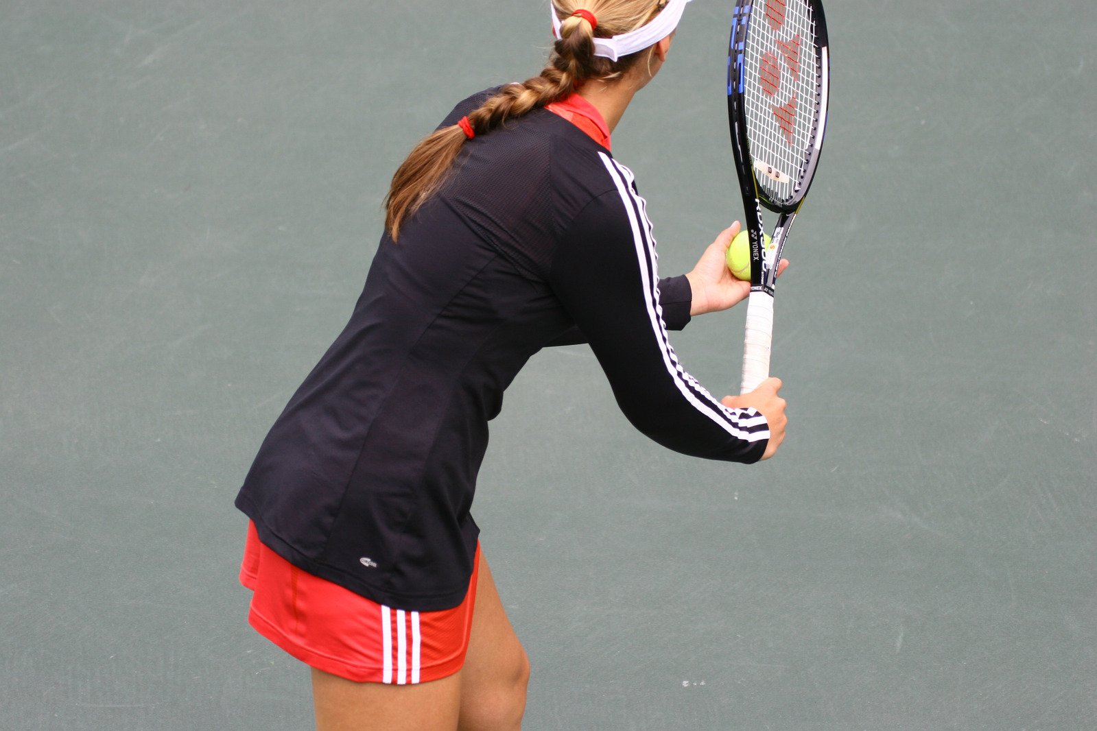 a woman holding up a tennis racquet on top of a tennis court