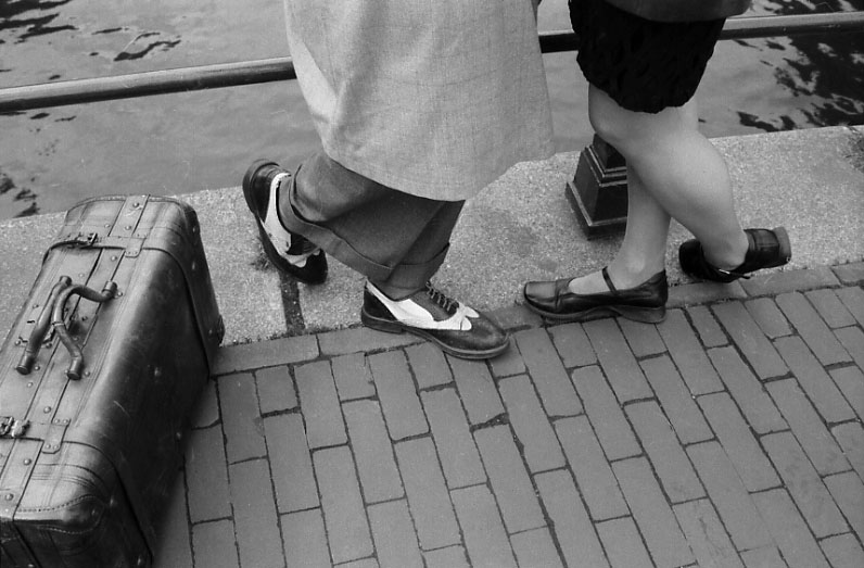 two people in sandals and sandals standing next to luggage