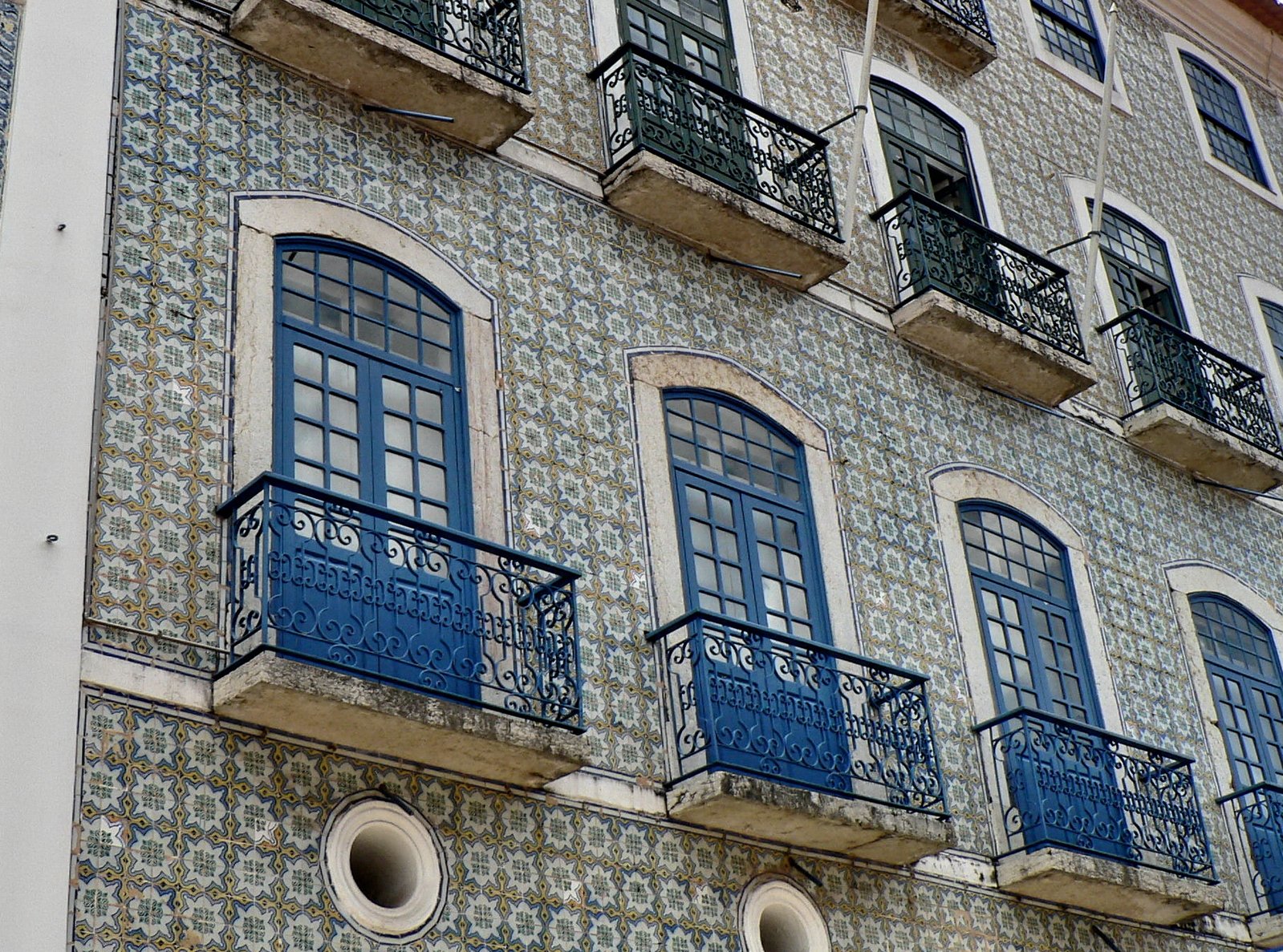 a blue and white tiled building with windows and balconies