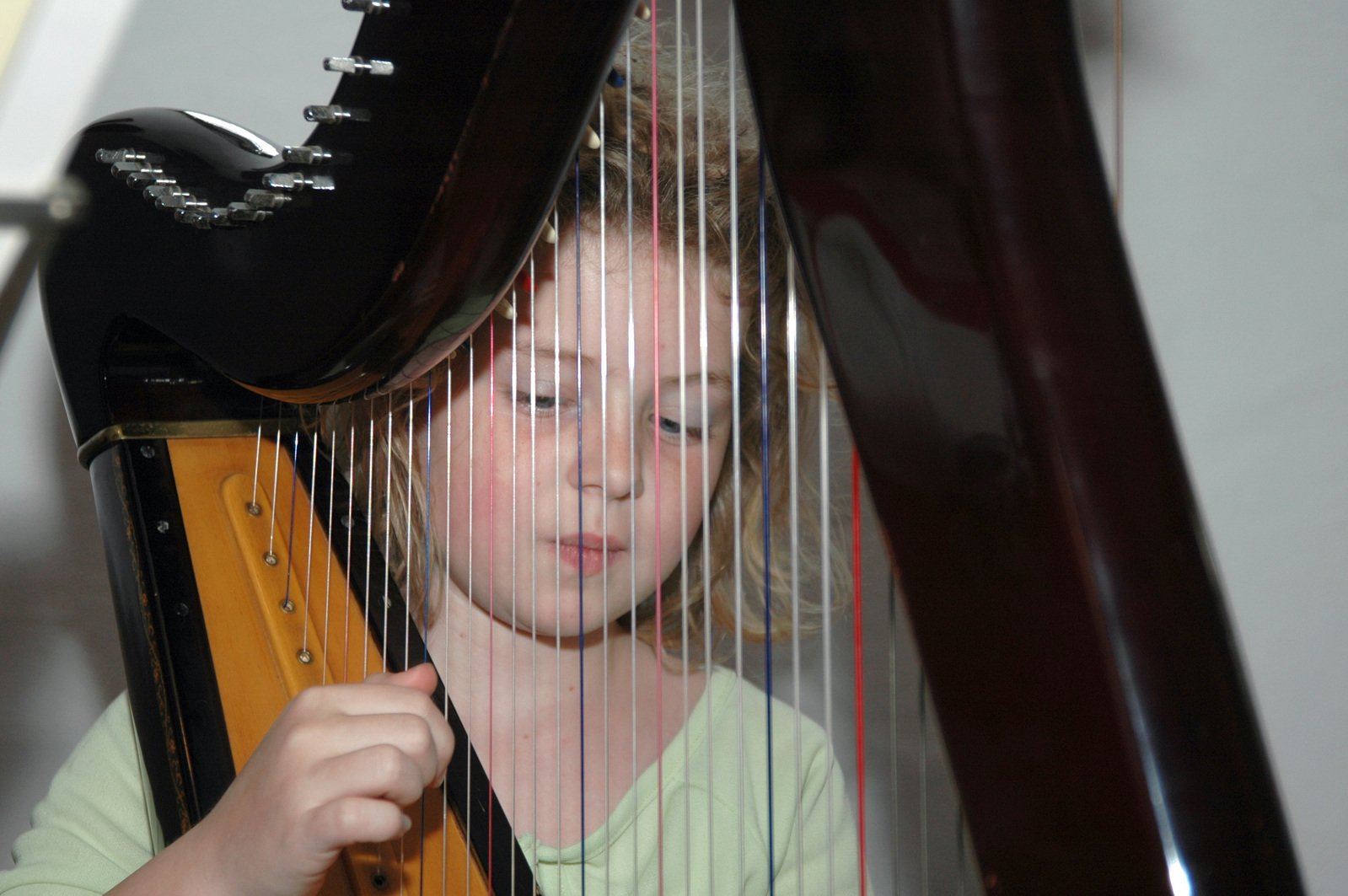 a small girl that is playing a harp