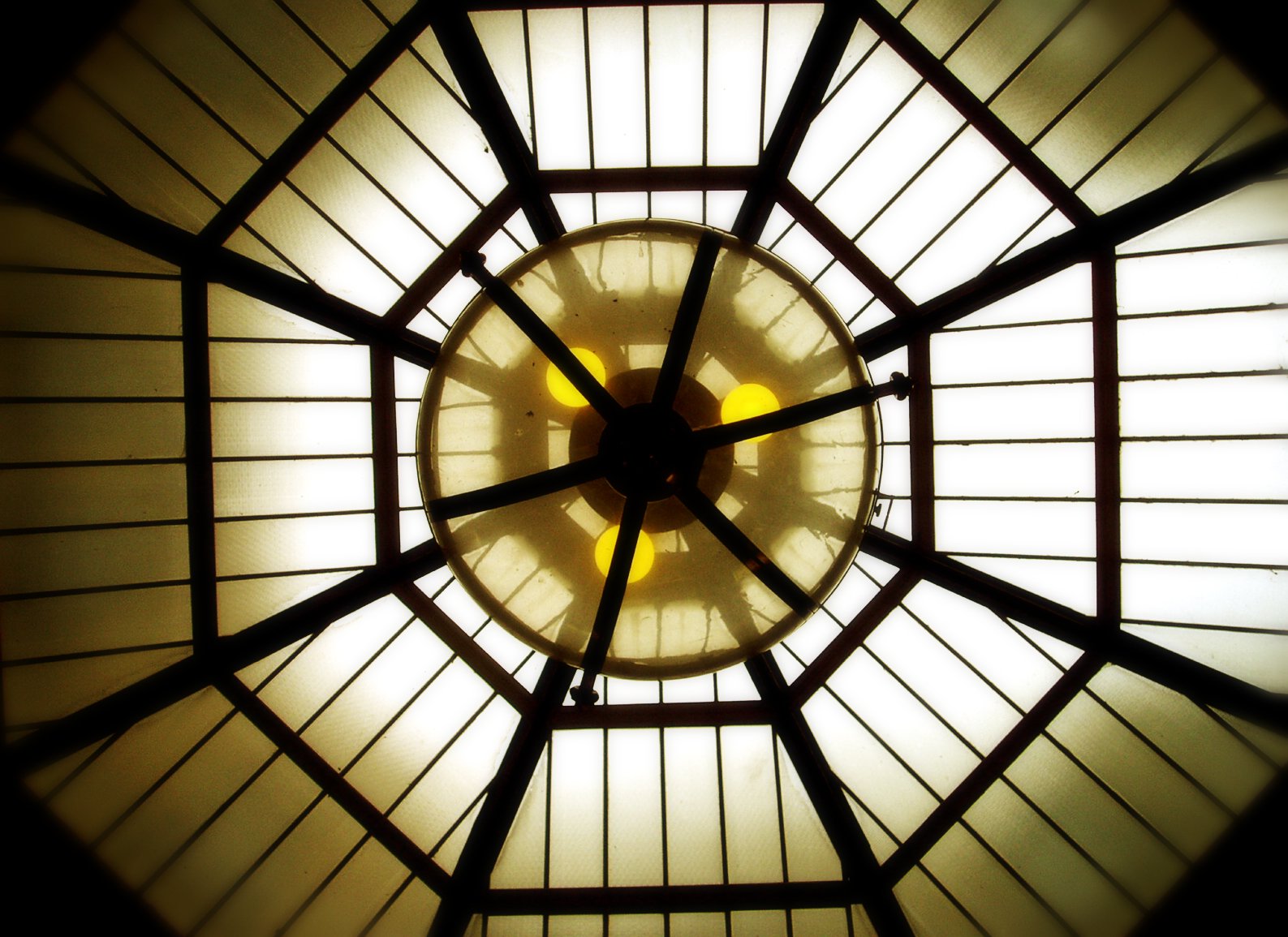 a view up into the center of a structure with a circular shaped ceiling light
