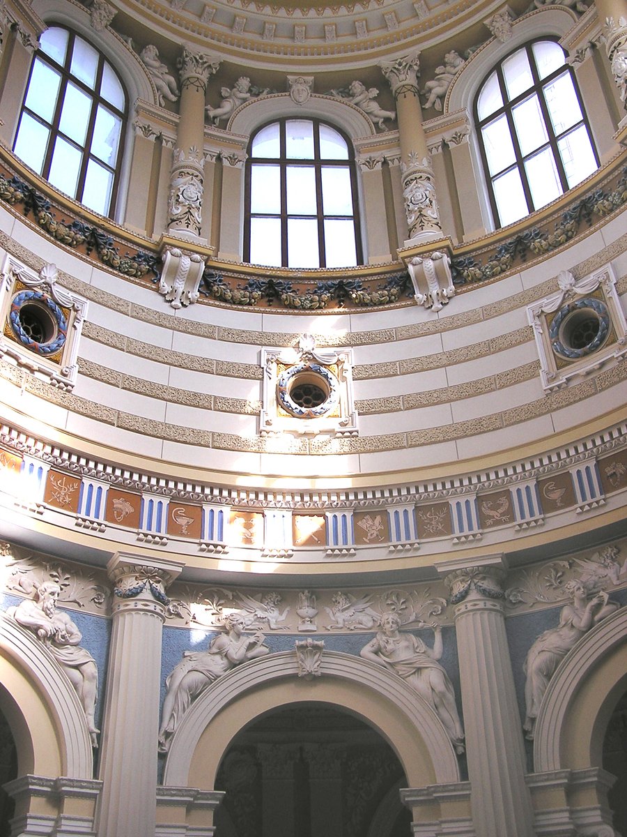 an ornate round room with columns and windows