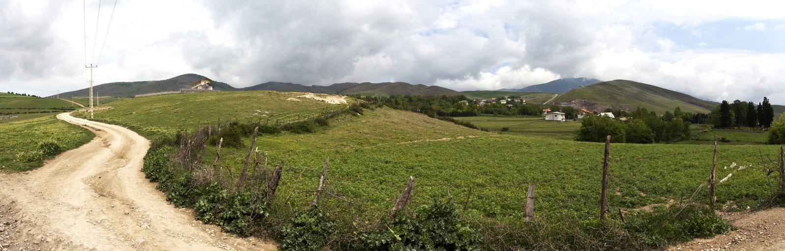 a dirt road going through the green hills