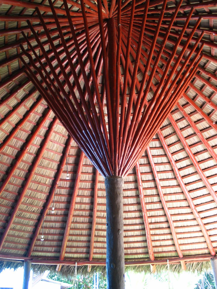 a bamboo umbrella sitting in the center of a roof