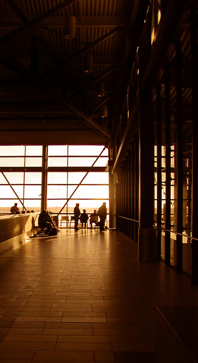 the inside of an airport terminal with passengers sitting in the lobby