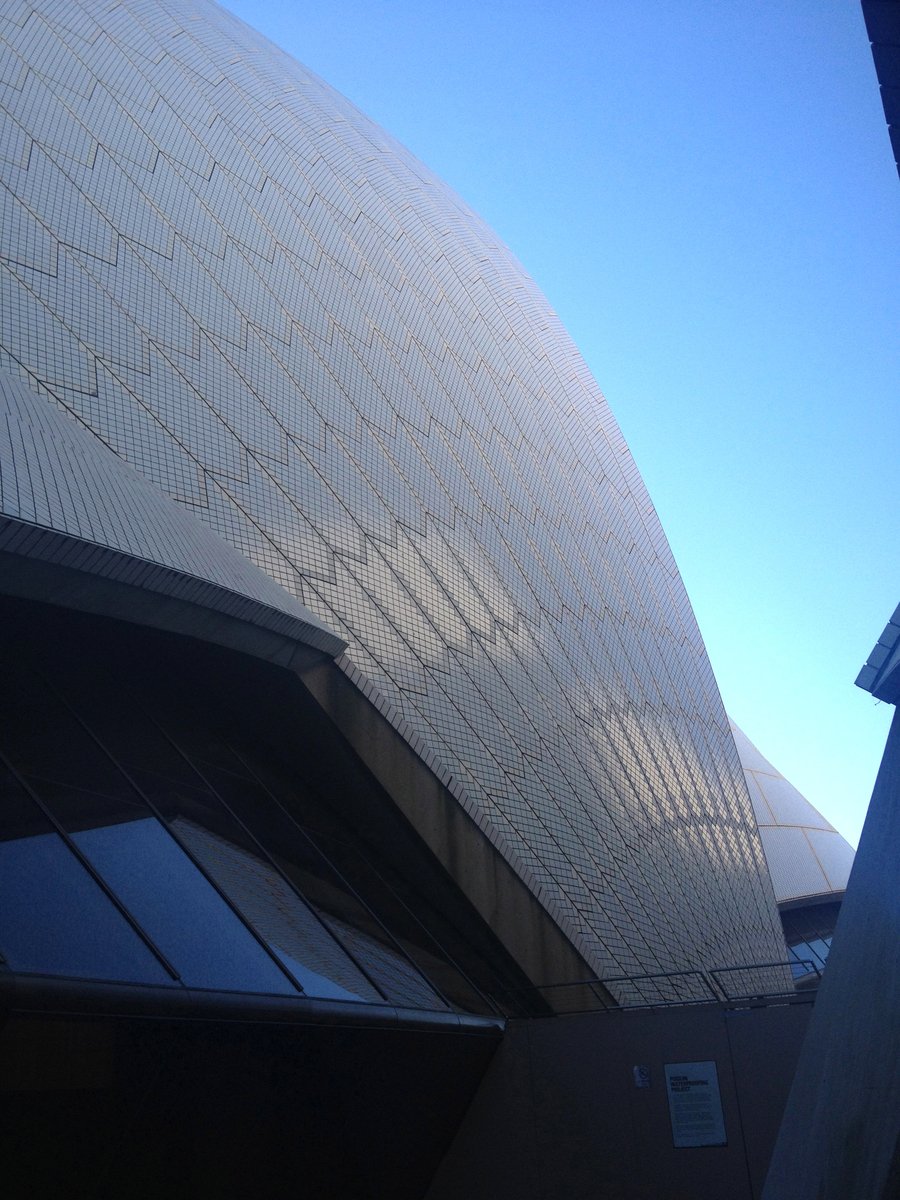 a building made of curved rocks under a bright blue sky