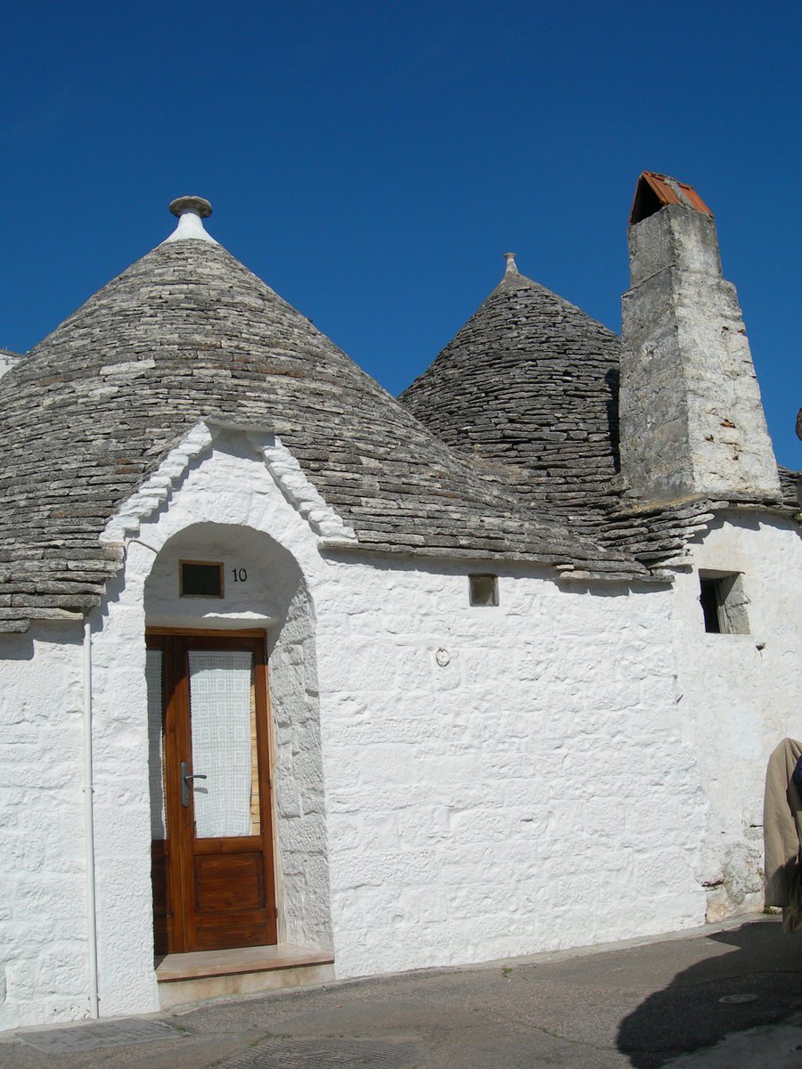 a white brick building has two chimneys and an opening