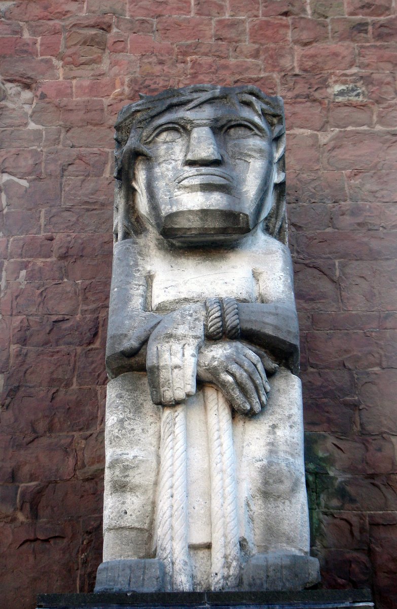 a large stone head sculpture on top of a building