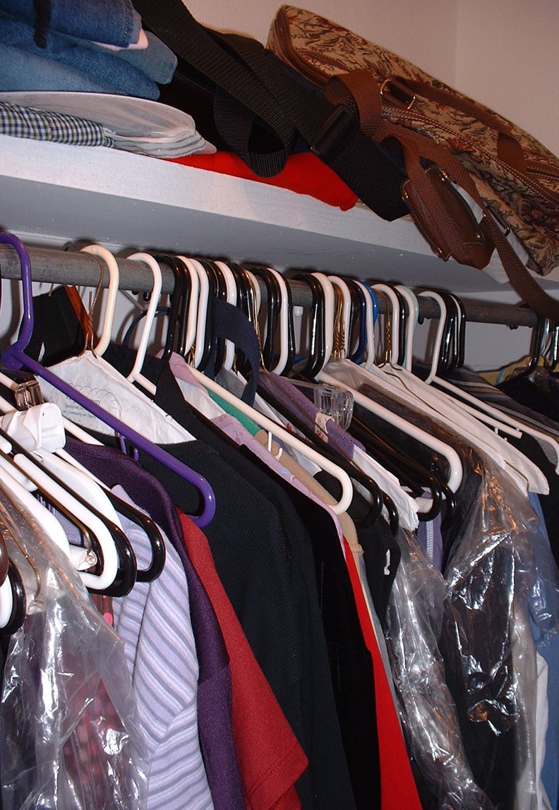 a closet that has clothes and clothes hanging