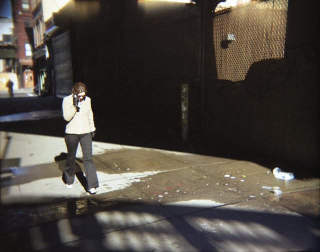a woman walking down the street talking on a cell phone