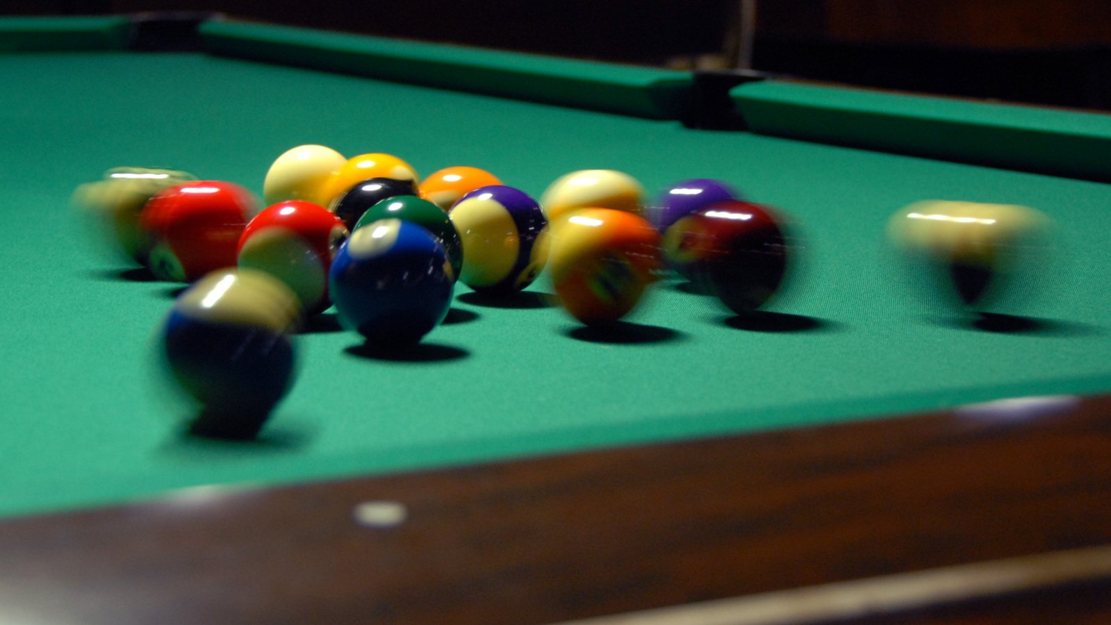 many colorful billiard balls laying on top of a pool table