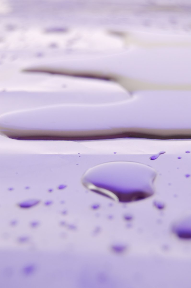 two drops of purple paint sitting on top of each other