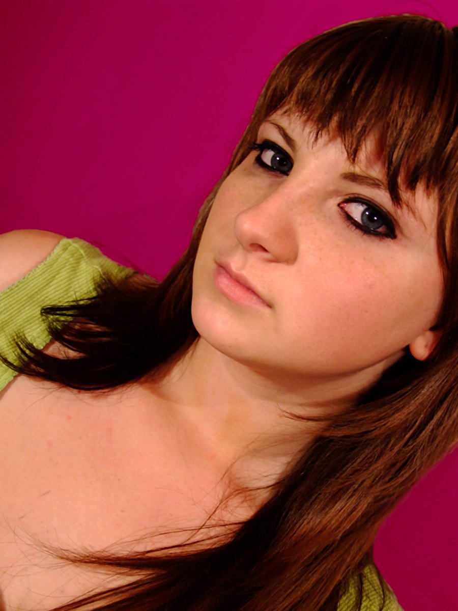 a beautiful young woman in a green dress posing for the camera