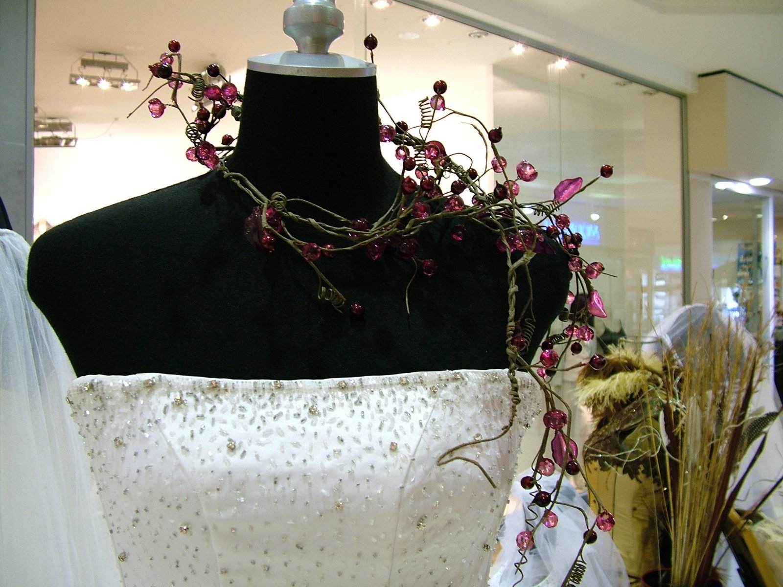 the bride's dress is decorated with flowers and leaves