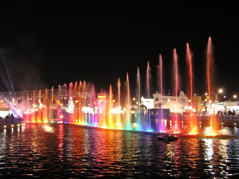 a group of fountains of water on top of a body of water