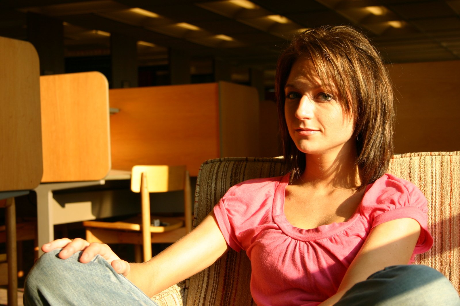 a pretty woman sitting on top of a chair in a room