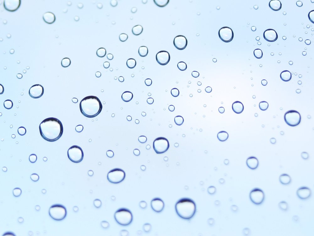 water drops are on a window glass as it is partly covering the ground
