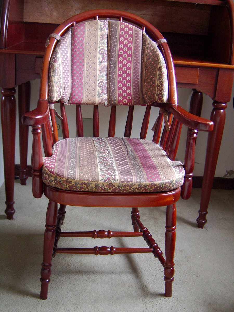 a chair sitting near some wooden desks