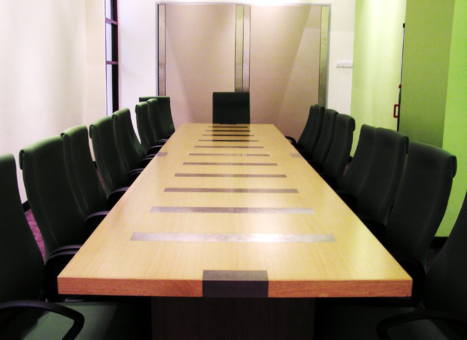 a long conference table sits in the middle of a meeting room