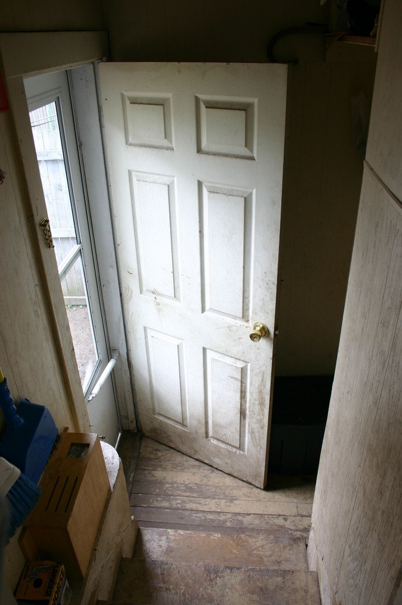a house door has an opened cardboard box beside it