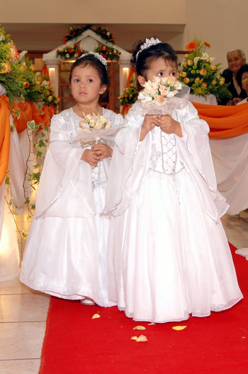 two s dressed in dresses with flowers and bouquets