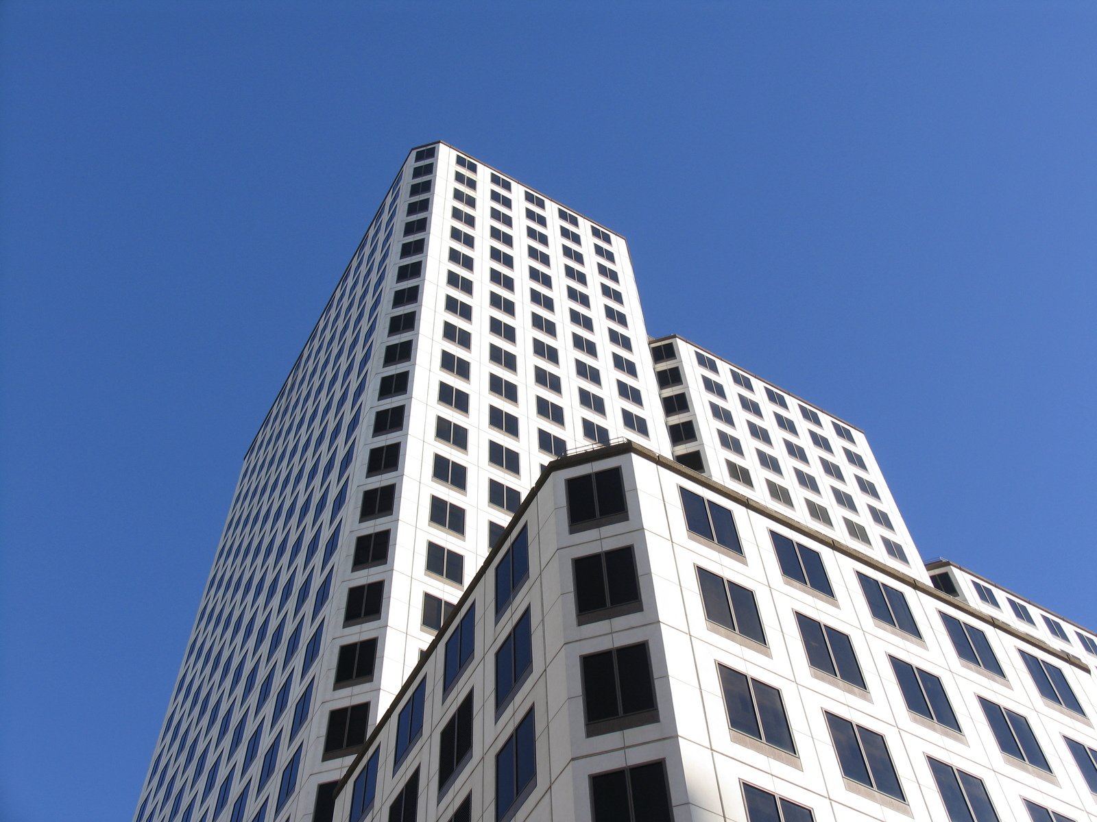 tall buildings stand against a blue sky on a sunny day