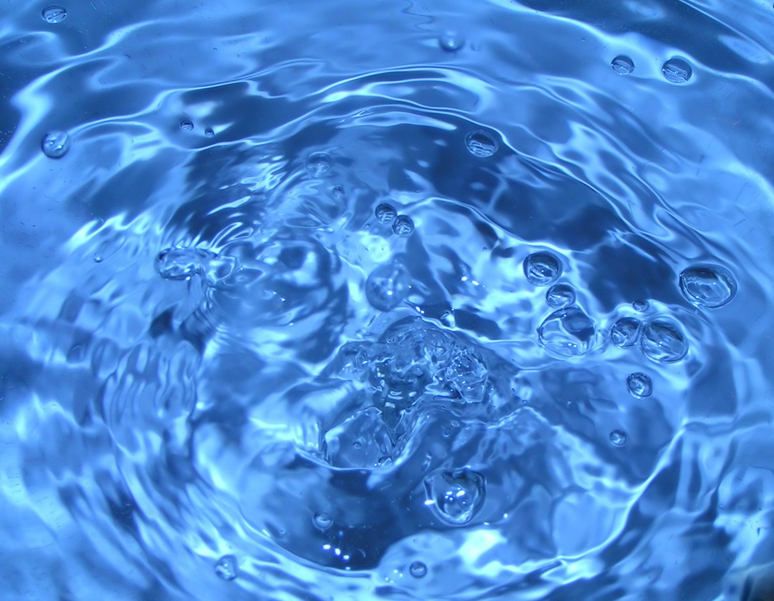 the top view of a blue water surface with bubbles