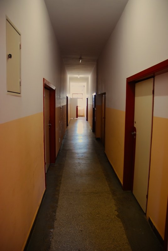 an empty hallway of a storage facility with closed doors