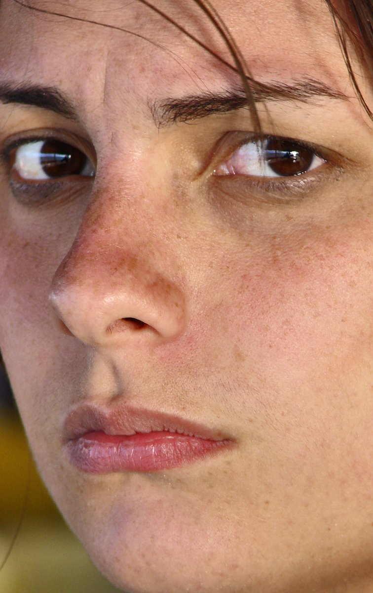 a close up of a womens face looking off into the distance