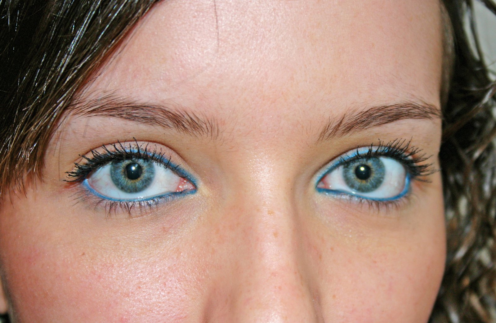 the girl's blue eyes are covered with mascara