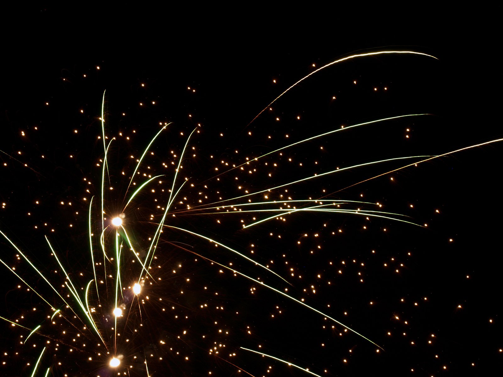 a very long row of shiny fireworks against a black sky