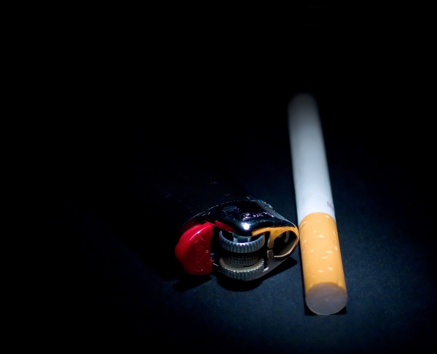 a cigarette sitting next to a glass bottle