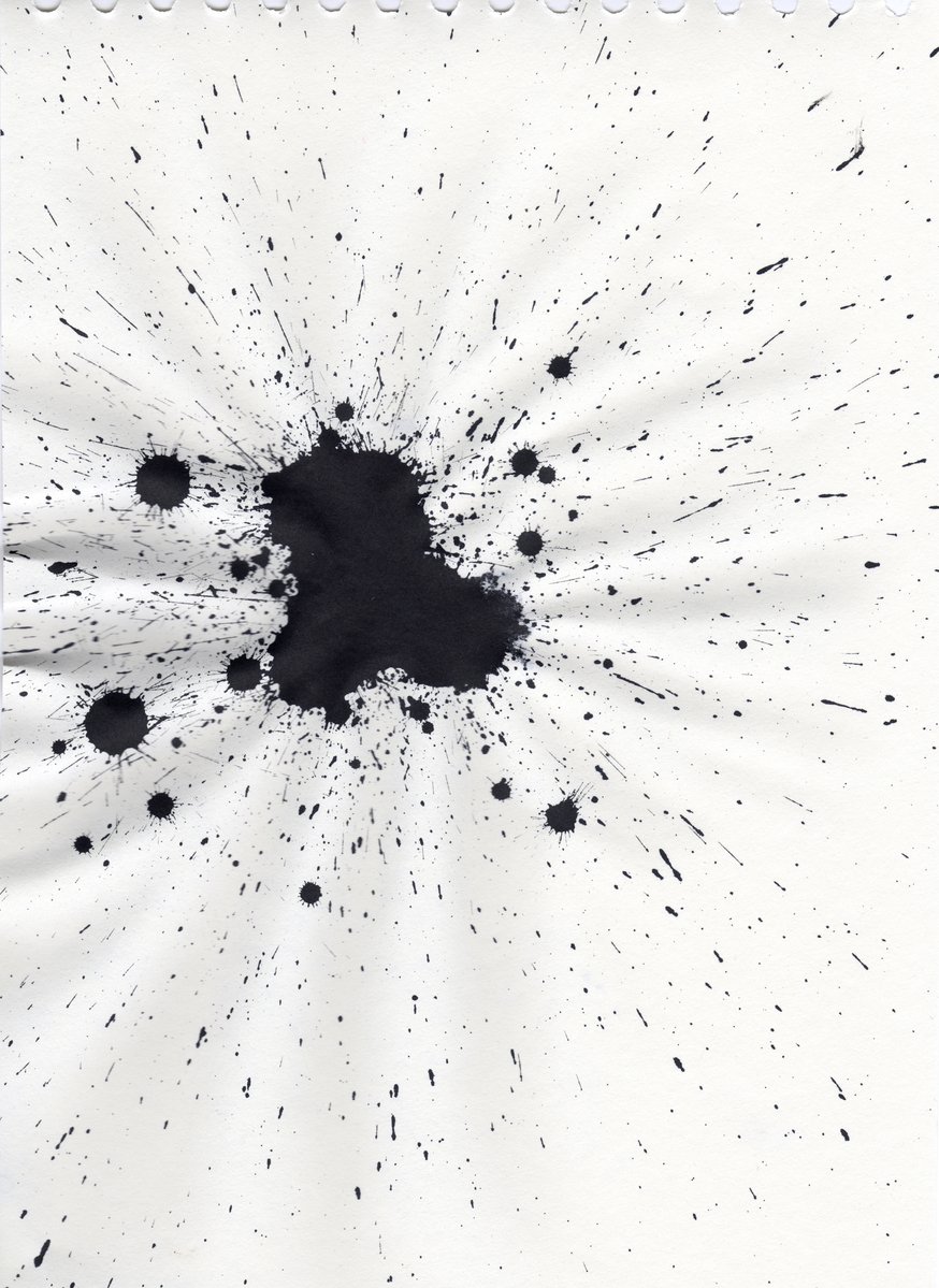 an ink blotch with lots of black spots on white paper