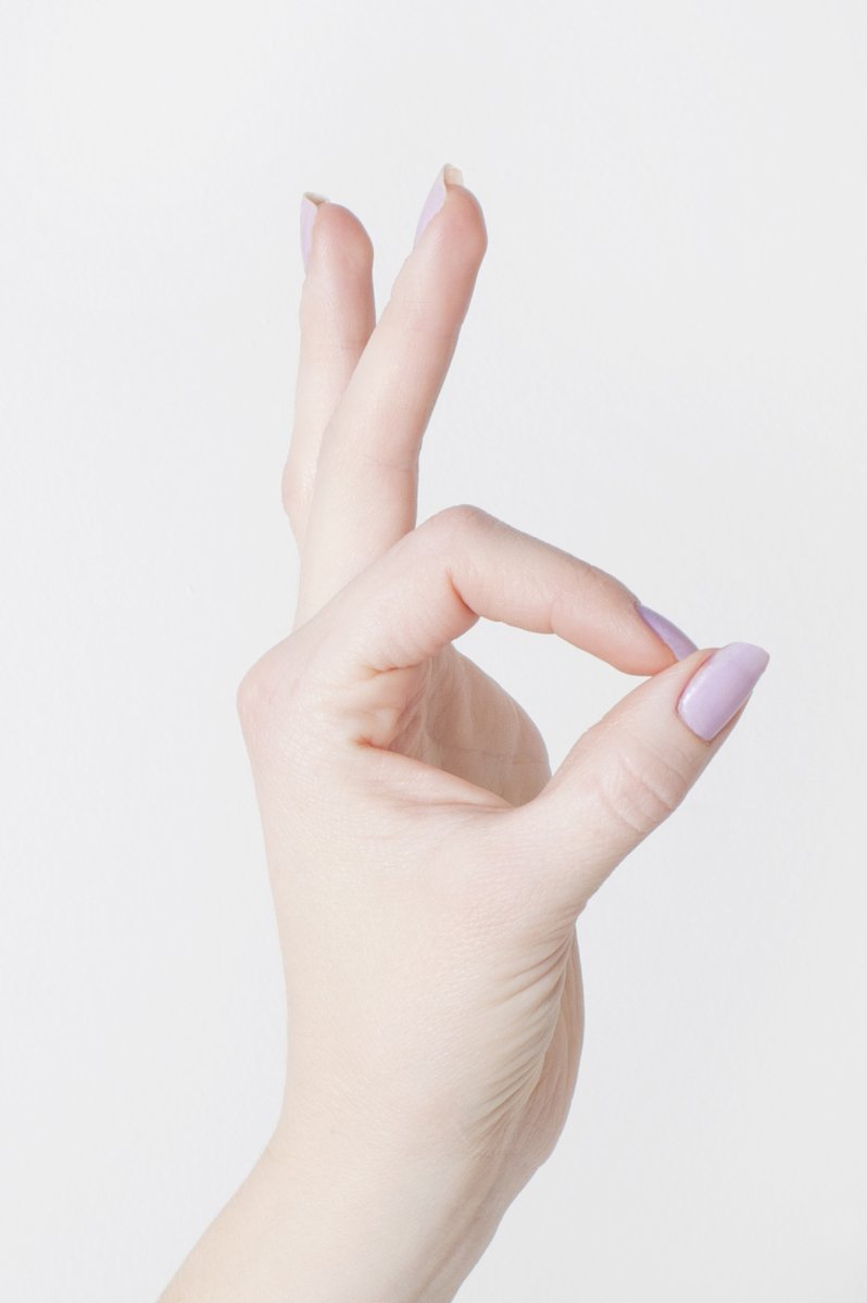 a woman's hand with long nails holding up her finger