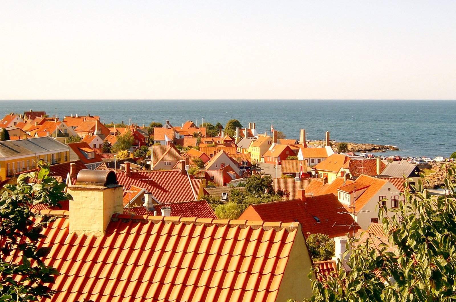 the roofs of small, colorful houses overlooks a vast ocean